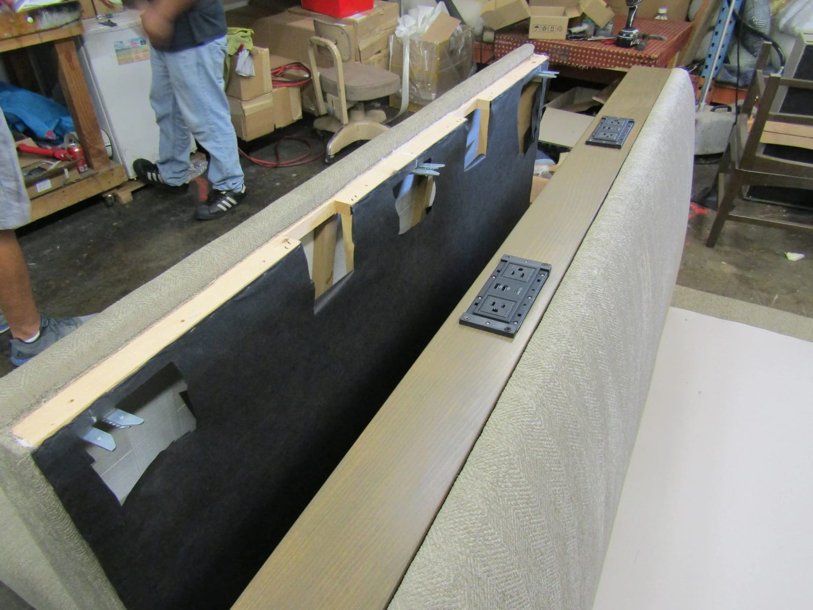 An upholstered banquette with power outlets set into its top rail
