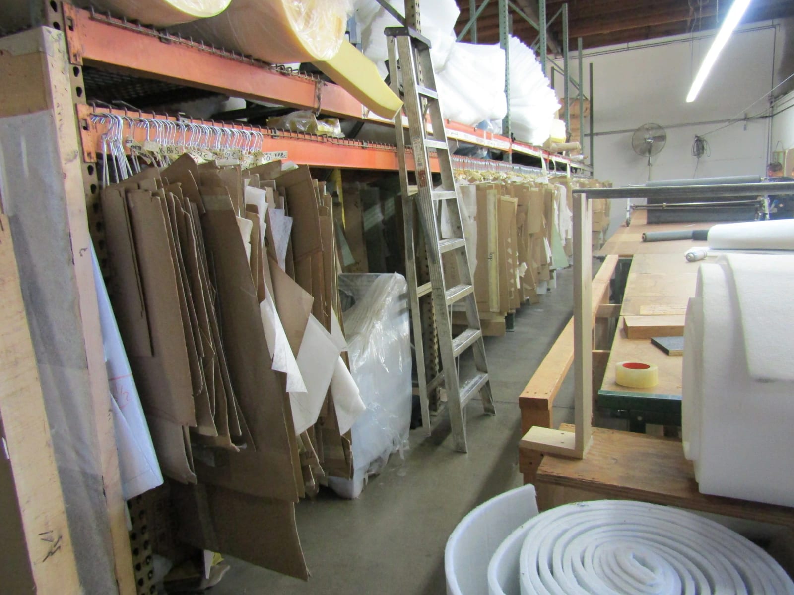 Paper patterns hanging on racks beside rolls of foam